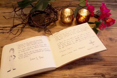 an open book on a table with candles and flowers at Grassmarket Old Town Boutique Apartment in Edinburgh