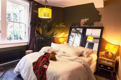 a dog laying on a bed in a bedroom at Grassmarket Old Town Boutique Apartment in Edinburgh