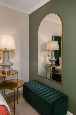 a room with a green couch and a mirror at Emerald Suite, The Stirling Residence in Stirling
