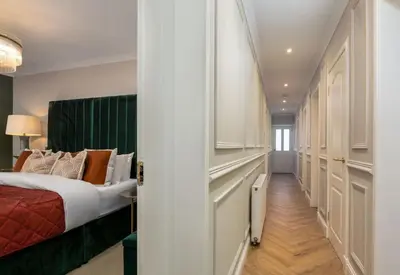 a hotel room with a bed and a hallway at Emerald Suite, The Stirling Residence in Stirling
