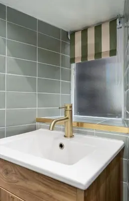 a white sink in a bathroom with a window at Bridgend Studio - Near Free Parking in Stirling