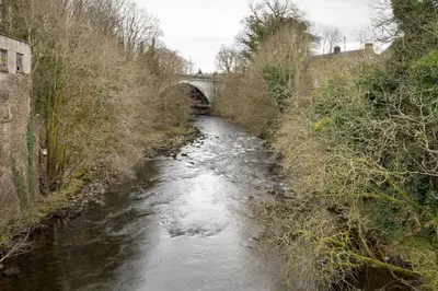 a river with a bridge in the background at Bridgend Studio - Near Free Parking in Stirling