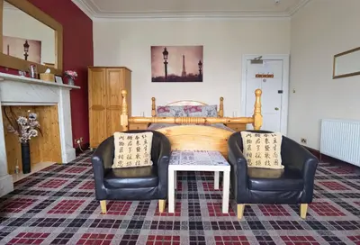 a bedroom with a bed and two chairs at Summer's Bay in Rothesay