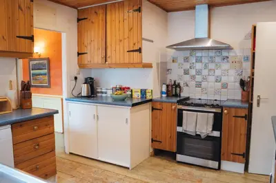 a kitchen with wooden cabinets and a stove top oven at Ardtalnaig House, Loch Tay in Ardtalnaig