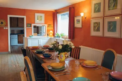 a dining room with a long wooden table with chairs at Ardtalnaig House, Loch Tay in Ardtalnaig