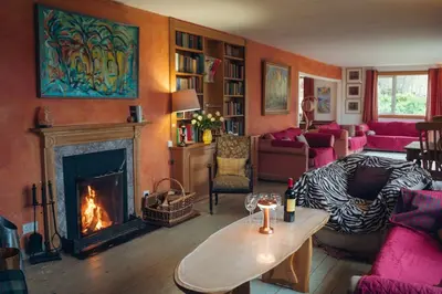 a living room with a fireplace and a couch at Ardtalnaig House, Loch Tay in Ardtalnaig