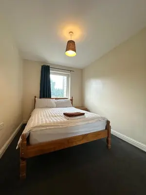 a bedroom with a large bed with a window at 2 Bed & 2 Bath-Flat-Driving Distance to Edinburgh in Uphall