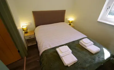 a small bedroom with a bed with towels on it at Fun holiday lodges in historic walled garden near Falkirk, Heart of Scotland Holidays in Falkirk