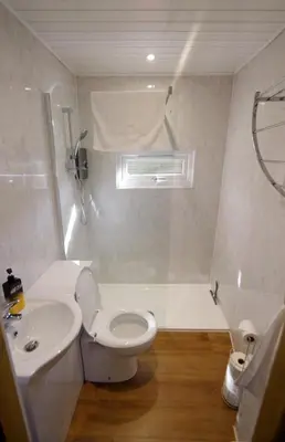 a bathroom with a white toilet and a sink at Fun holiday lodges in historic walled garden near Falkirk, Heart of Scotland Holidays in Falkirk