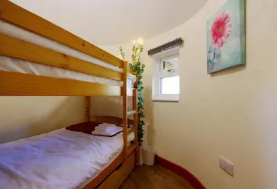 a bedroom with a bunk bed and a window at Fun holiday lodges in historic walled garden near Falkirk, Heart of Scotland Holidays in Falkirk