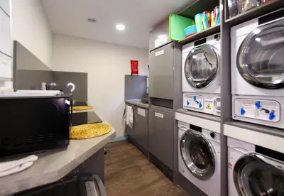 a laundry room with three washer and dryers at Fun holiday lodges in historic walled garden near Falkirk, Heart of Scotland Holidays in Falkirk