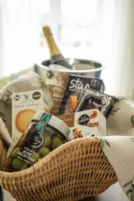 a basket filled with food and a bottle of wine at Stirling Townhouse Apartment Btm in Stirling