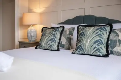 a white bed with two pillows and a lamp at Stirling Townhouse Apartment Mid in Stirling