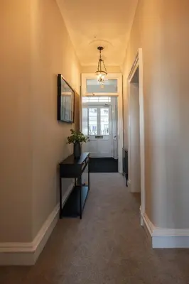 a hallway with a table with a plant on it at Stirling Townhouse Apartment Mid in Stirling