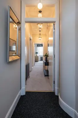 a hallway leading into a room with a mirror at Stirling Townhouse Apartment Mid in Stirling