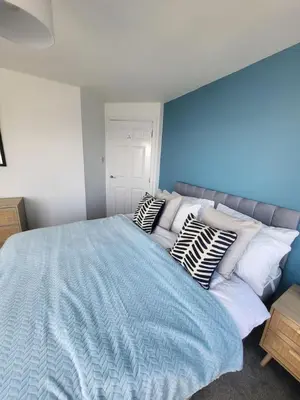 a bedroom with a large bed with pillows on it at Harbour Point -Coorie Doon Stays in Saltcoats