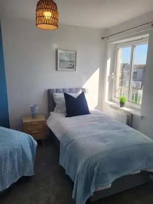 a bedroom with a bed and a window at Harbour Point -Coorie Doon Stays in Saltcoats