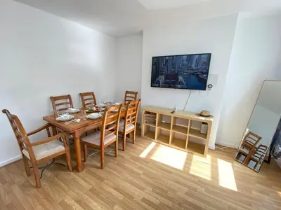 a dining room with a wooden table and chairs at Luxurious 3 rooms greater London in Moffat