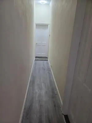 an empty hallway with a white refrigerator in a room at Carlton road in Moffat