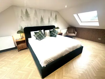 a bedroom with a large bed in a attic at Fergus in ApartNest Auchterarder in Auchterarder