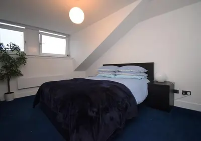 a bedroom with a bed with pillows on it at Stylish Central Flat George Sq in Glasgow