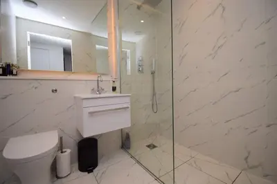 a bathroom with a toilet and a glass shower at Stylish Central Flat George Sq in Glasgow