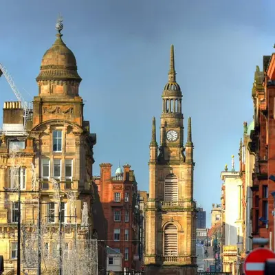 an old building with a clock tower in a city at Stylish Central Flat George Sq in Glasgow