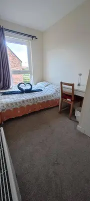 a bedroom with a bed with a window and a desk at Cosy Room with Shared Bathroom in Edinburgh