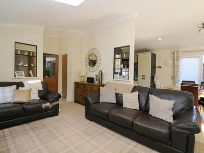 a living room with two black leather couches at RoseGrace Lodge in Auchterarder