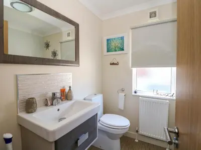 a bathroom with a sink and a toilet and a mirror at RoseGrace Lodge in Auchterarder