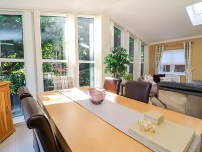 a dining room with a table and a living room at RoseGrace Lodge in Auchterarder