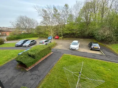a group of cars parked in a parking lot at Cosy two bedroom flat in Glasgow