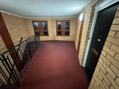 an empty hallway with stairs and a red carpet at Cosy two bedroom flat in Glasgow