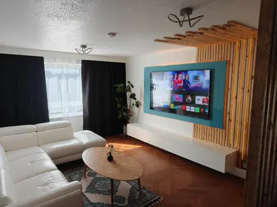 a living room with a white couch and a flat screen tv at Modern 2 Bed Flat in East Kilbride