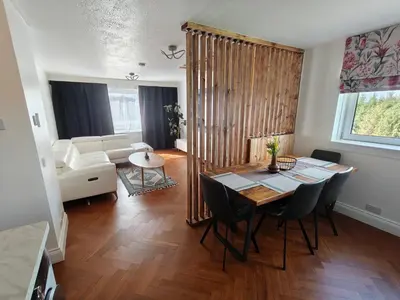 a living room with a table and chairs and a couch at Modern 2 Bed Flat in East Kilbride