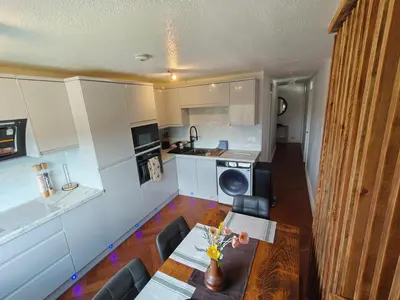 a small kitchen with a table and a dining room at Modern 2 Bed Flat in East Kilbride