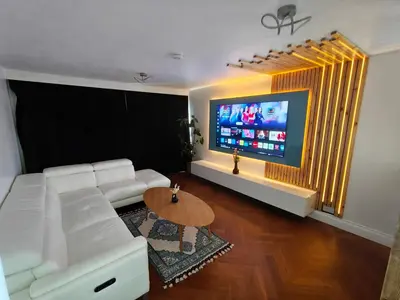 a living room with a white couch and a flat screen tv at Modern 2 Bed Flat in East Kilbride
