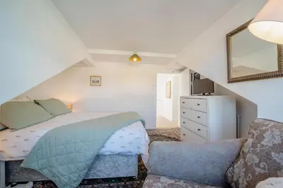 a bedroom with a bed and a couch and a mirror at 2 Bed in Moffat oc-a32121 in Moffat