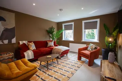 a living room with a red couch and chairs at Newly Renovated House in Popular Location in Glasgow