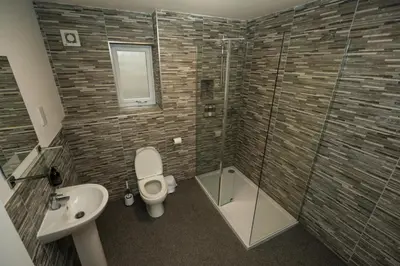 a bathroom with a toilet and a sink and a shower at Macallan Apartment in Oban