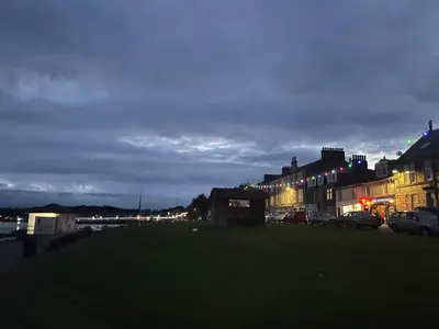 a city at night with cars parked on the street at Kames Bay Couples Retreat in Millport