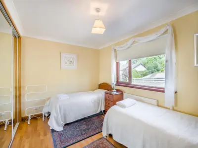 a bedroom with two beds and a window at Kilbride in Lamlash