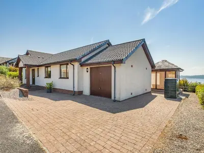 a house with a brick driveway in front of it at Kilbride in Lamlash