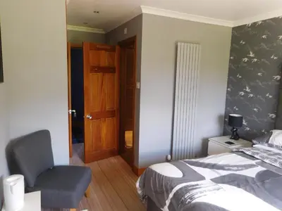 a bedroom with a bed and a chair in it at Riverside House in Callander