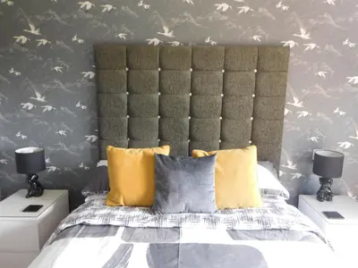 a bedroom with a large bed with yellow pillows at Riverside House in Callander