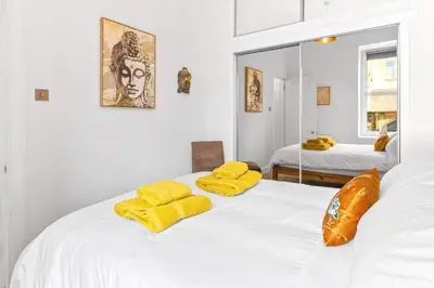 a bedroom with two beds with yellow towels on them at Stunning 2BR Apt - Central, Argyll Square Views in Oban