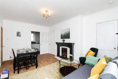 a living room with a couch and a fireplace at 3Bedroom Apartment-Free Parking in Falkirk