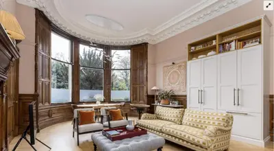 a living room with a couch and a table at Luxury Wood panelled West End GF Flat in Edinburgh