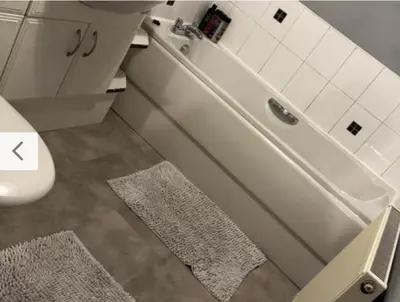 a bathroom with a sink and a toilet with two rugs at Old Town Place in Edinburgh