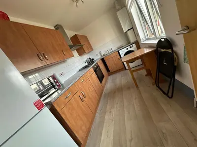 a kitchen with wooden cabinets and a wooden floor at Old Town Place in Edinburgh